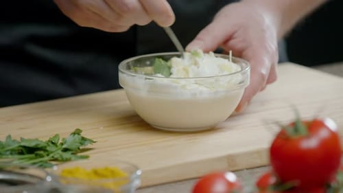 Creamy Sauce Being Mixed with Herbs and Spices