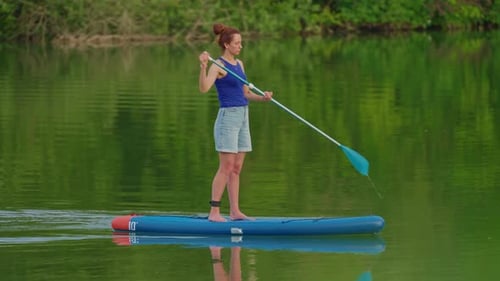 Alone Woman Floating on Stand Up Paddle Board in Lake in Summertime Standup Paddleboarding Surfer