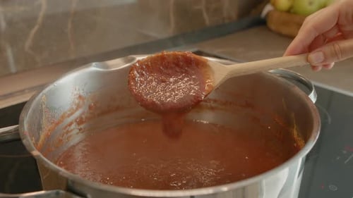 Red Jam being Stirred in Metal Pot