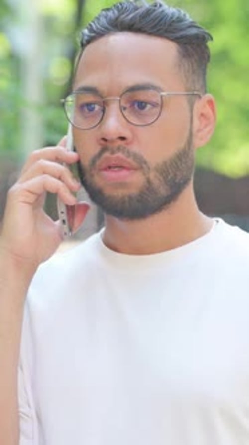 Vertical video, Man Talking on Phone Outdoor in Park