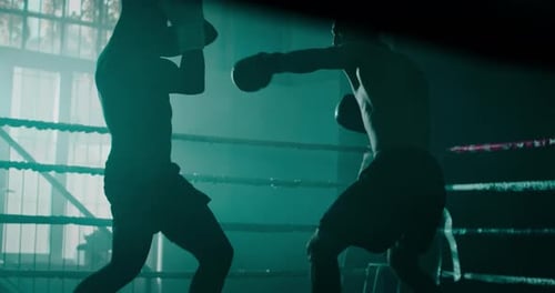 Filmmusik Zeitlupenaufnahme von zwei professionellen jungen, muskulösen männlichen Boxern ohne Hemd, kämpfen i