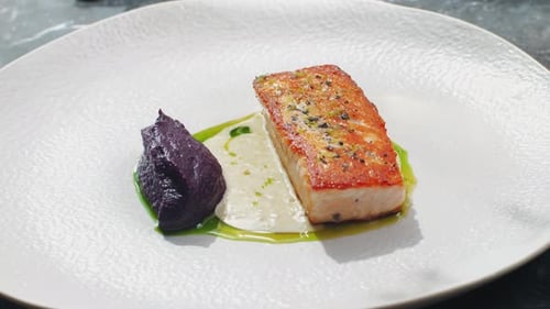 Grilled Salmon Steak with Sesame Seeds and Garnish in Modern Expensive Restaurant Close Up Shot of