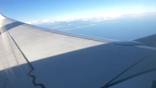 Airplane flying over the clouds wing view