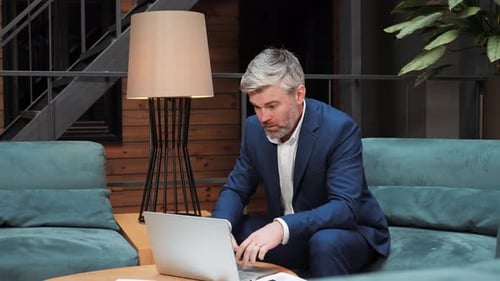 Un homme d'affaires malade travaillant sur un ordinateur portable ressent un chagrin soudain