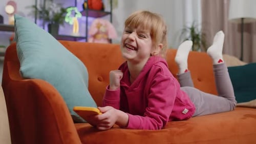 Girl Lies on Couch and Plays on Phone