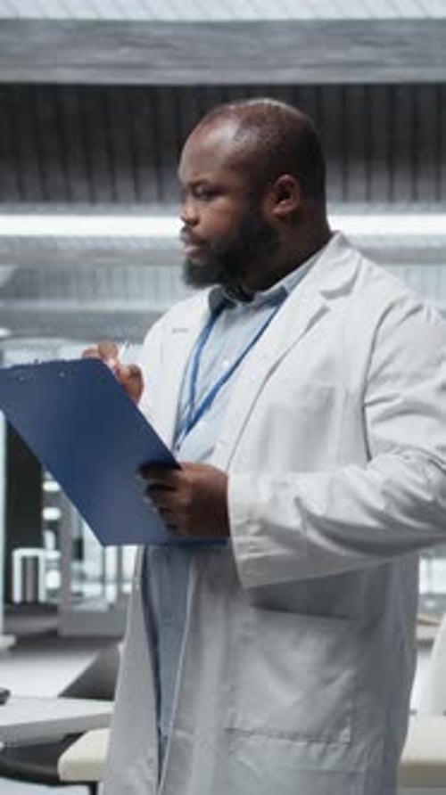 Focused doctor writes on clipboard in hospital