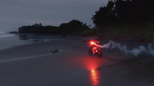 Figure on Motorcycle with Lights on Tropical Beach