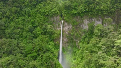 Majestic Waterfall Flows Through Tropical Green Forest