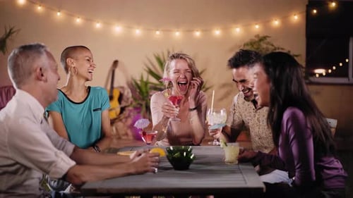 Friends Toasting Cocktails at Outdoor Evening Gathering