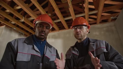 Kollegen diskutieren Bauprojekt auf der Baustelle