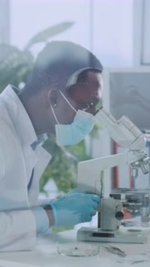 Male Scientist Using Microscope in Laboratory Environment