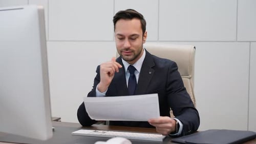 Focused Businessman Reviewing Documents in Modern Office