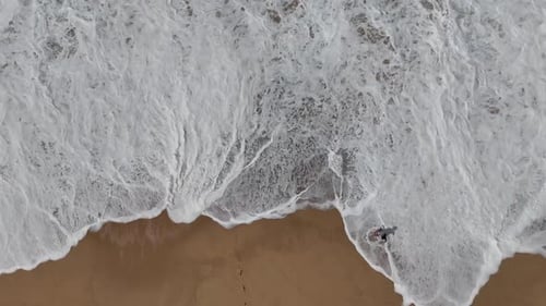 Aerial Perspective of Waves Gently Crashing on a Beautiful Sandy Beach on a Sunny Day