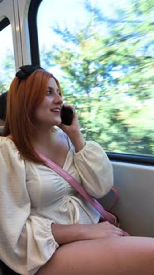 Young Woman Talking on Phone While Riding Urban Train