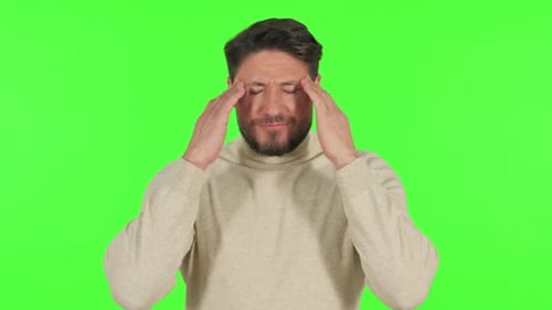 Middle Aged Man with Headache on Green Background
