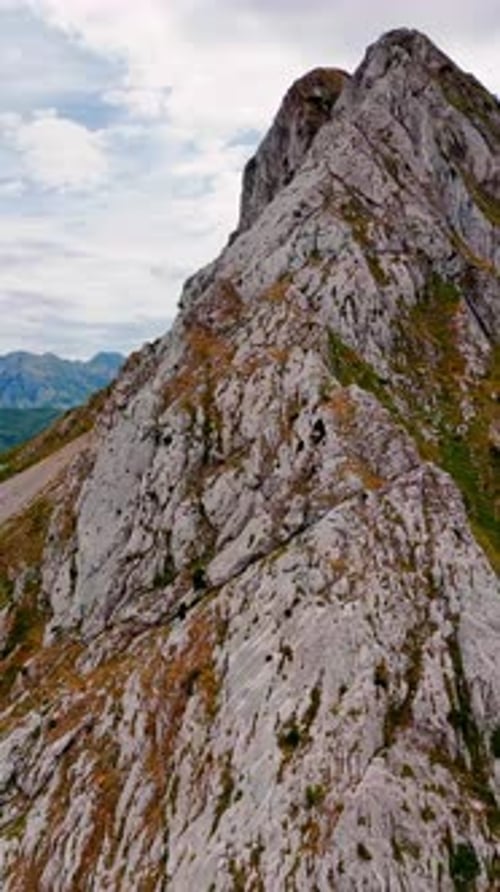 Footage close at the huge grey rock with some lichens growing on.