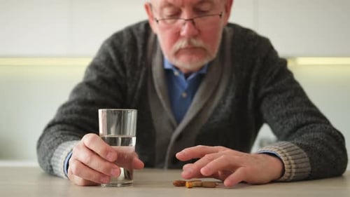 Senior Man with Pills and Water Indoors