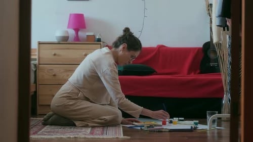 Young Woman Painting Art on the Floor