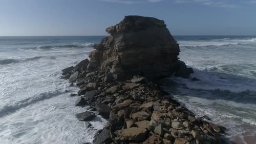Large rock in the blue sea on a sunny day. Aerial view Rocky cliff in the ocean in Portugal