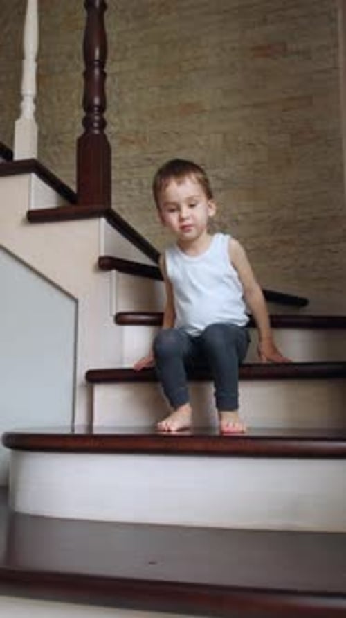 Young Child Walks Down Stairs at Home