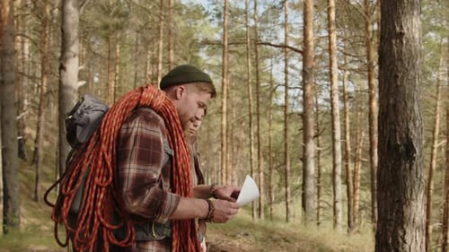 Hikers Studying Map in Pine Tree Forest