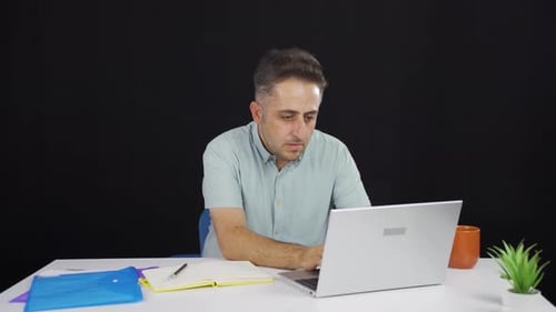 Man closing laptop with angry expression.