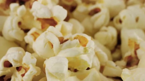 Rotating popcorn grains. Popcorn background. Macro and close-up.