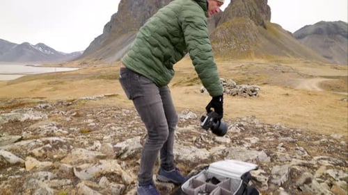 Photographer Sets Up Camera on Mountain Landscape