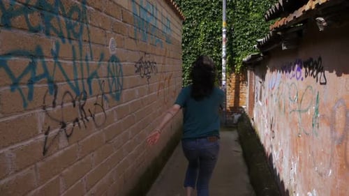 Verängstigte, verängstigte junge Frau rennt durch kleine Häuser. Flucht, Angst, Gefahr