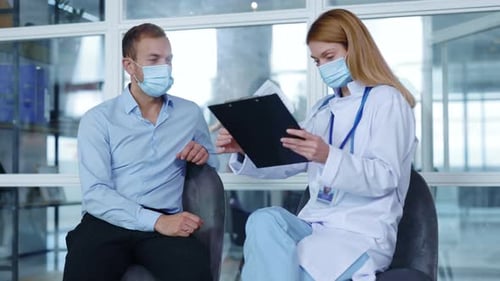 In Hospital Man with Medical Mask Sitting Speaking with Woman Doctor About Diagnosis During
