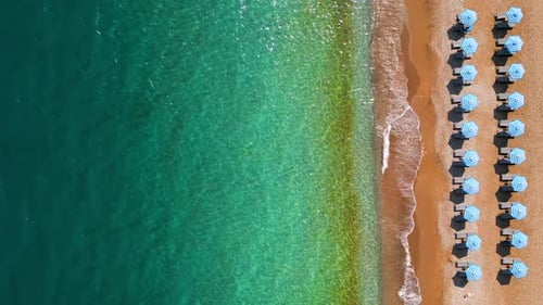 Topdown View of Sandy Beach with Sun Umbrellas and Turquoise Sea Water