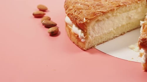 Cutting a Delicious Almond Cake with Cream Filling