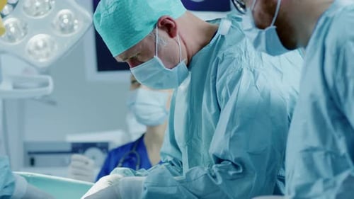 In the Hospital Operating Room Diverse Team of Professional Surgeons and Nurses Suture Wound after