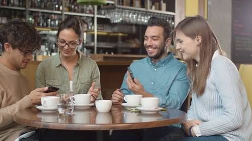 Group of Young Mixed race People using Phones in Coffee Shop.