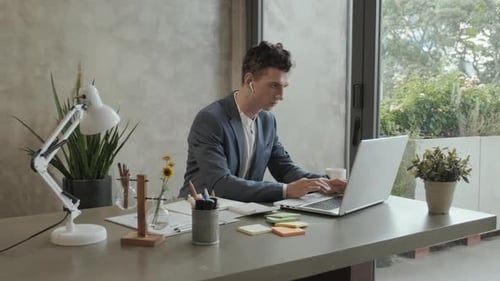 Man Working on Laptop in Bright Office