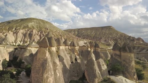 Aerial drone fly away push-out shot of the chimney rock pillars of Goreme / Uçhisar in Cappadocia, T