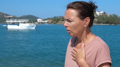 Adult Woman Using Inhaler by Ocean on Sunny Day