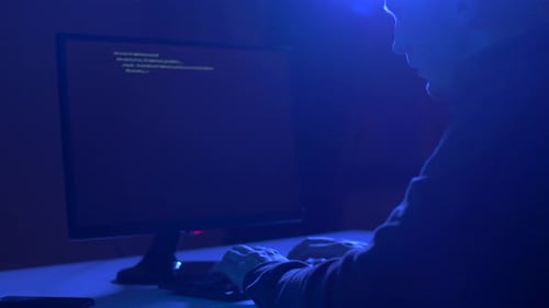 Cybercrime, Hacking and Technology Concept - Male Hacker in Dark Room Writing