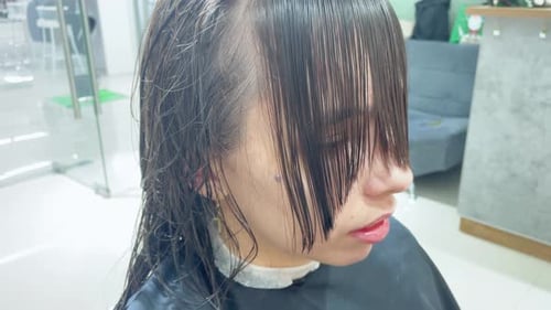 Woman Getting Bangs Trimmed at Hair Salon