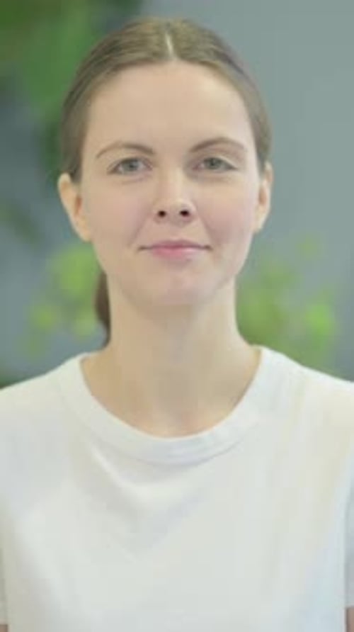 Smiling Woman Gives a Thumbs Up in Portrait Orientation