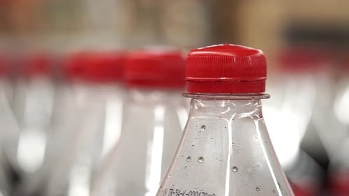 Bottles with Red Caps Lined Up in a Store Aisle