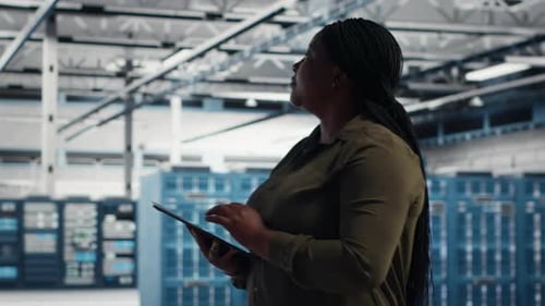 Technician Reviews Power Management with Green Screen Laptop in Data Center