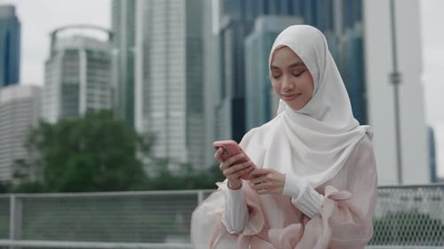 Young Woman Uses Phone in Urban Setting
