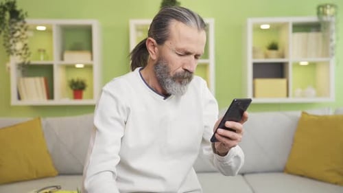 Senior Man Using Smartphone Indoors