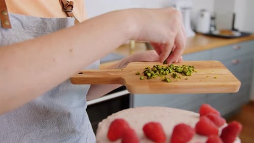 Konzept für Kulinarik, Backen und Kochen von Lebensmitteln — Frau dekoriert Himbeerkuchen mit
