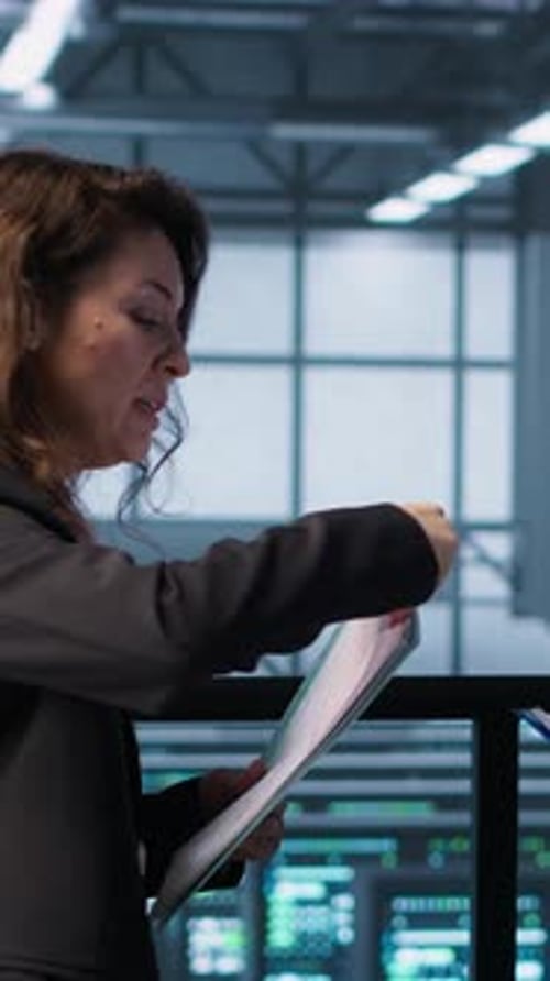 Vertical Video Data Center Team Examines Paperwork Files in Server Room Reviewing System