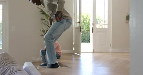 La porte d'entrée s'ouvre et un homme adulte entre et s'assoit à côté du garçon pour le réconforter