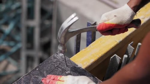 Close Up of Hammering Nail into Board