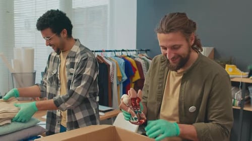 Trabajadores del centro de donaciones empacan la ropa necesaria para las personas necesitadas