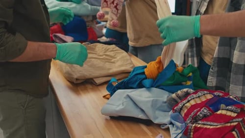 Trabajadores del centro de donaciones separan ropa de abrigo y ropa ligera para los refugiados
